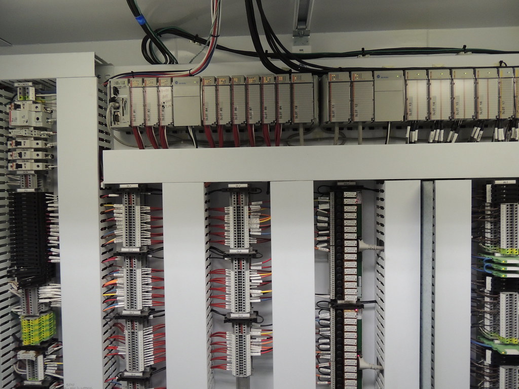 Rack de PLC con módulos de entradas y salidas y bornas de conexión en un cuadro de control industrial