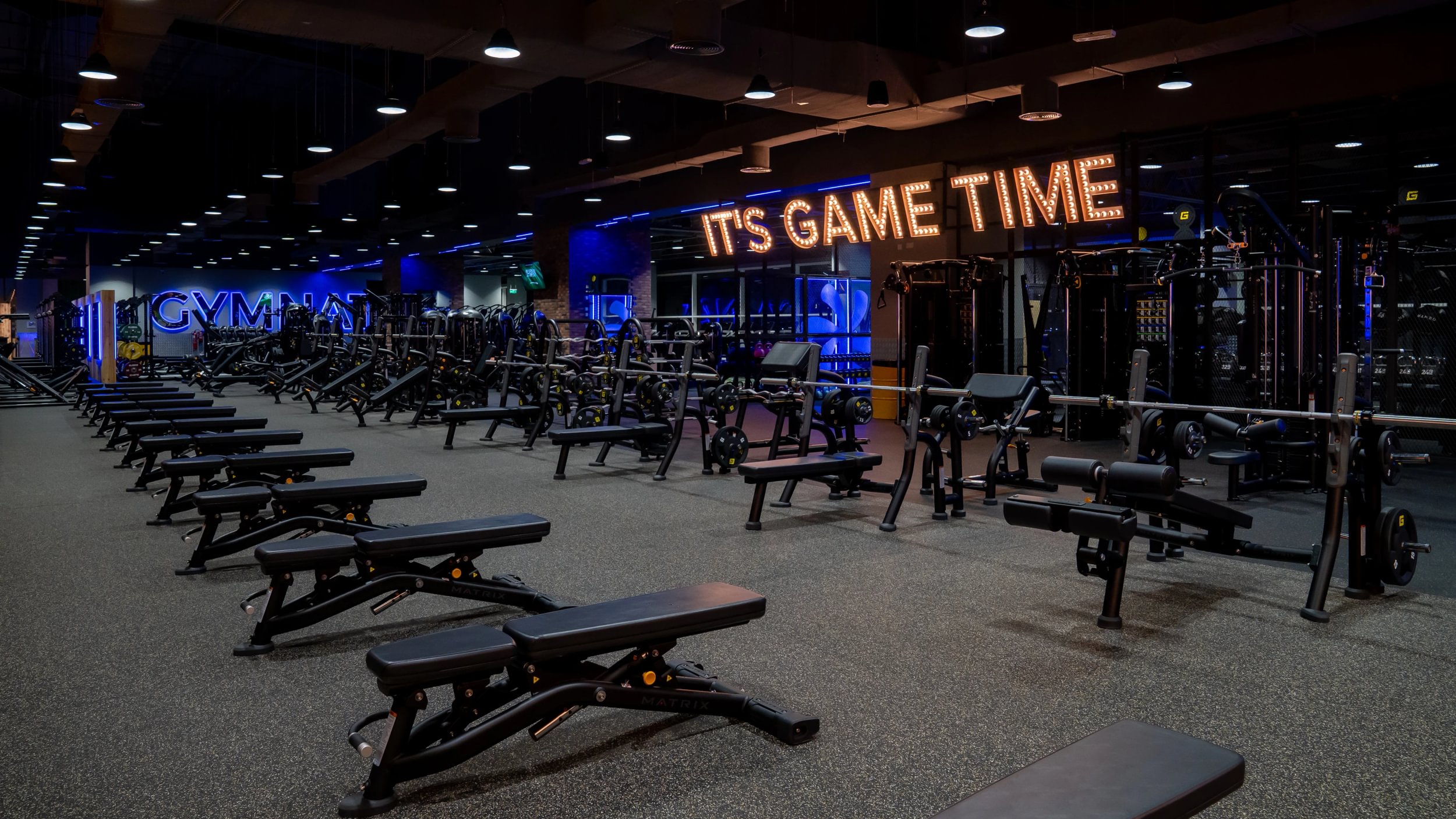 Interior de un gimnasio moderno con máquinas de musculación e iluminación LED en el techo