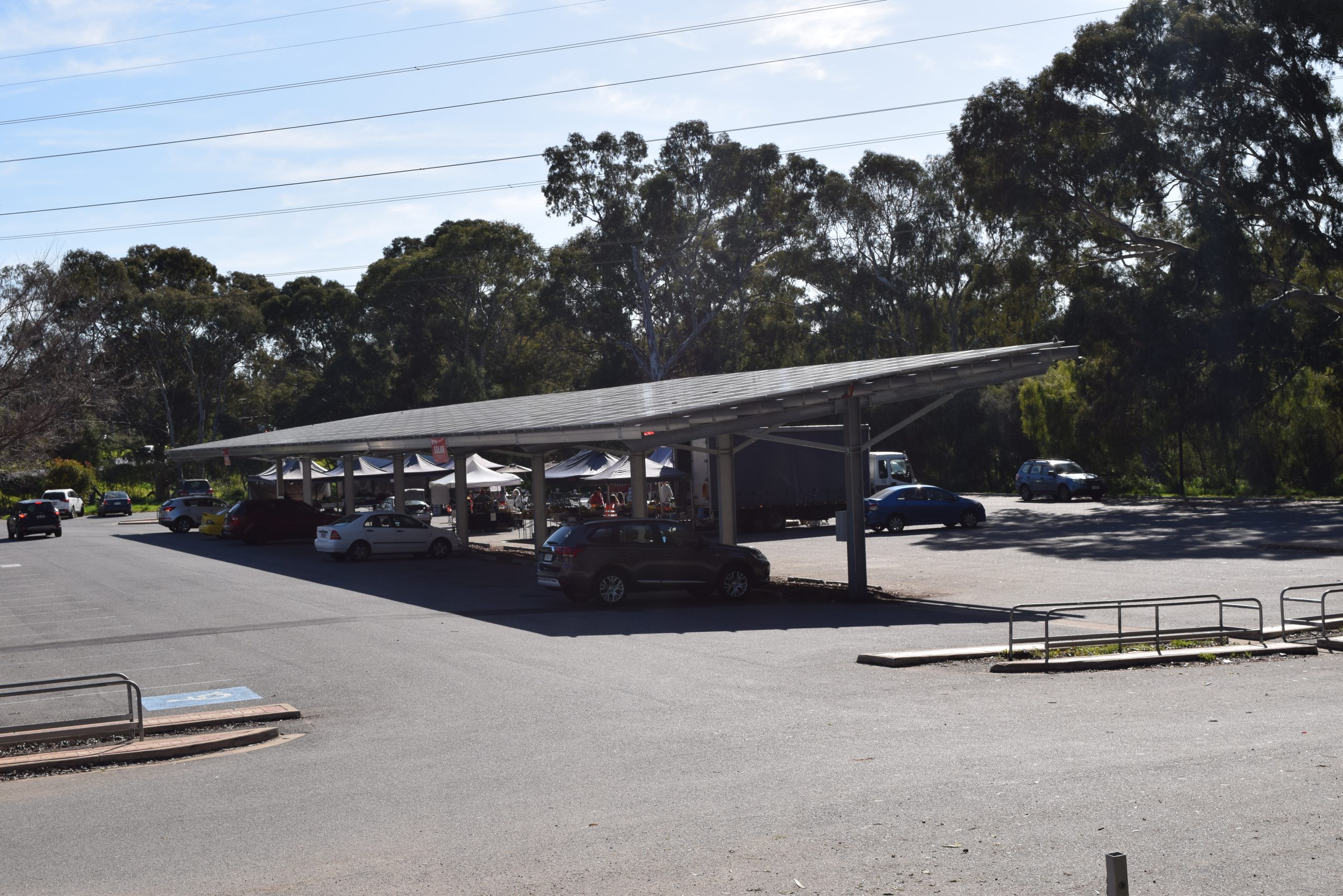 Marquesina solar fotovoltaica cubriendo un aparcamiento con coches debajo